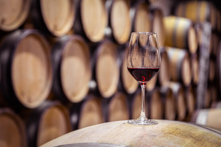 Un verre de vin rouge sur un fût de chêne