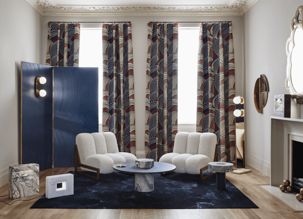 Un paravent constitué de deux panneaux de toile texturisée et laiton. Applique “Lolita”. Fauteuil “Théodore” en noyer. © DR